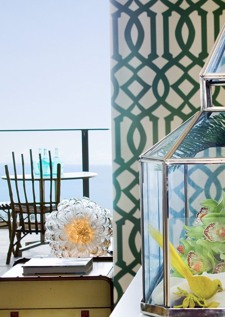 balcony with ocean view trellis wallpaper glass terrarium and bamboo chair coastal eclectic decor