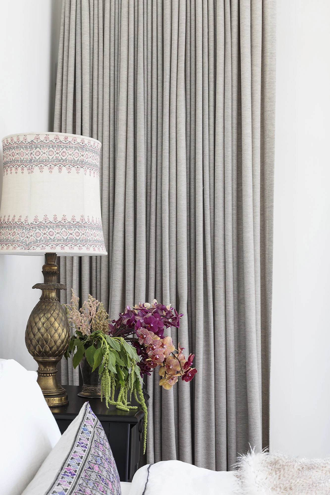 Linen drapery panels with block print Roman shade and brass lamp — layered textile window design by Bronwyn Poole