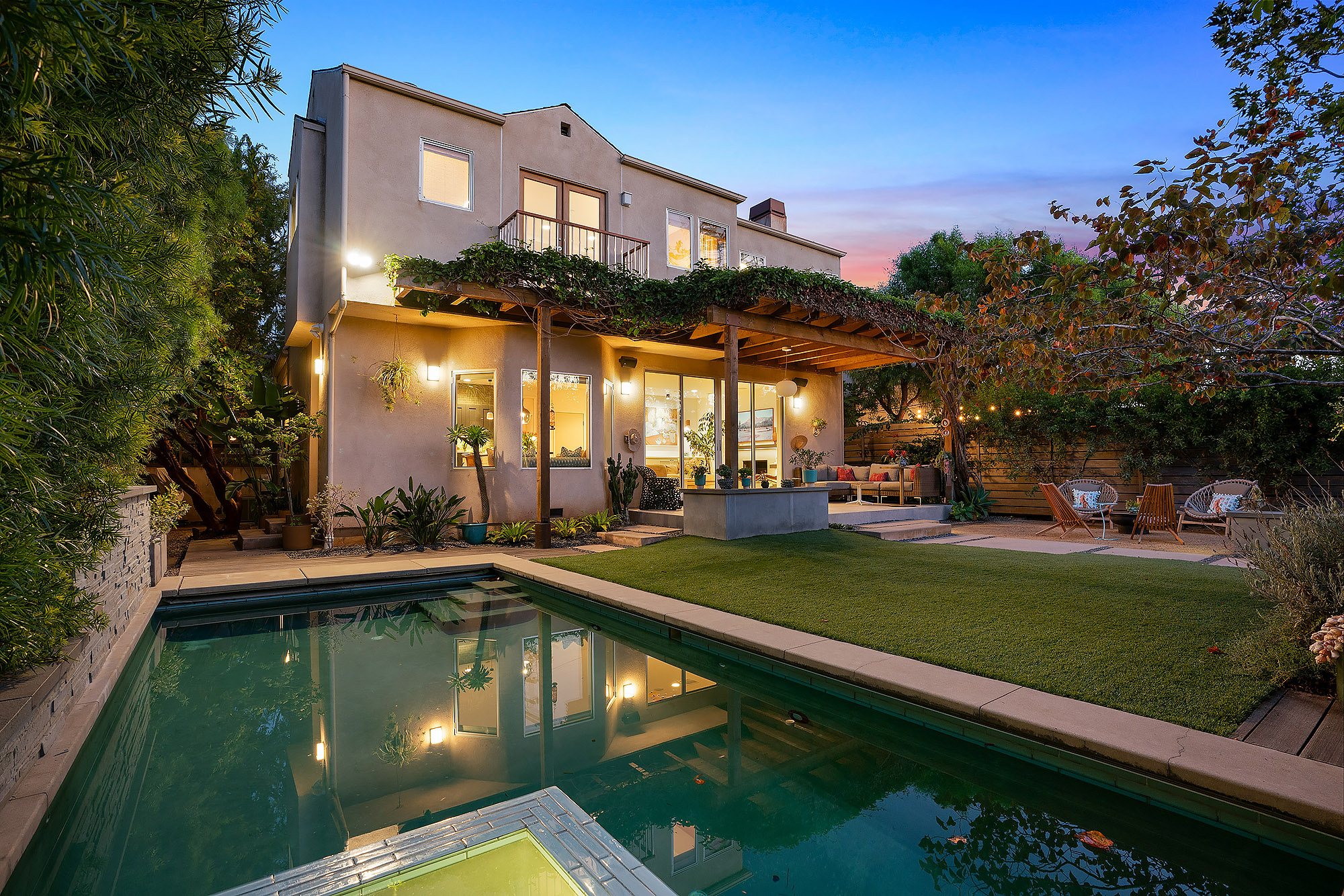 California backyard with pool pergola and outdoor lounge area at twilight