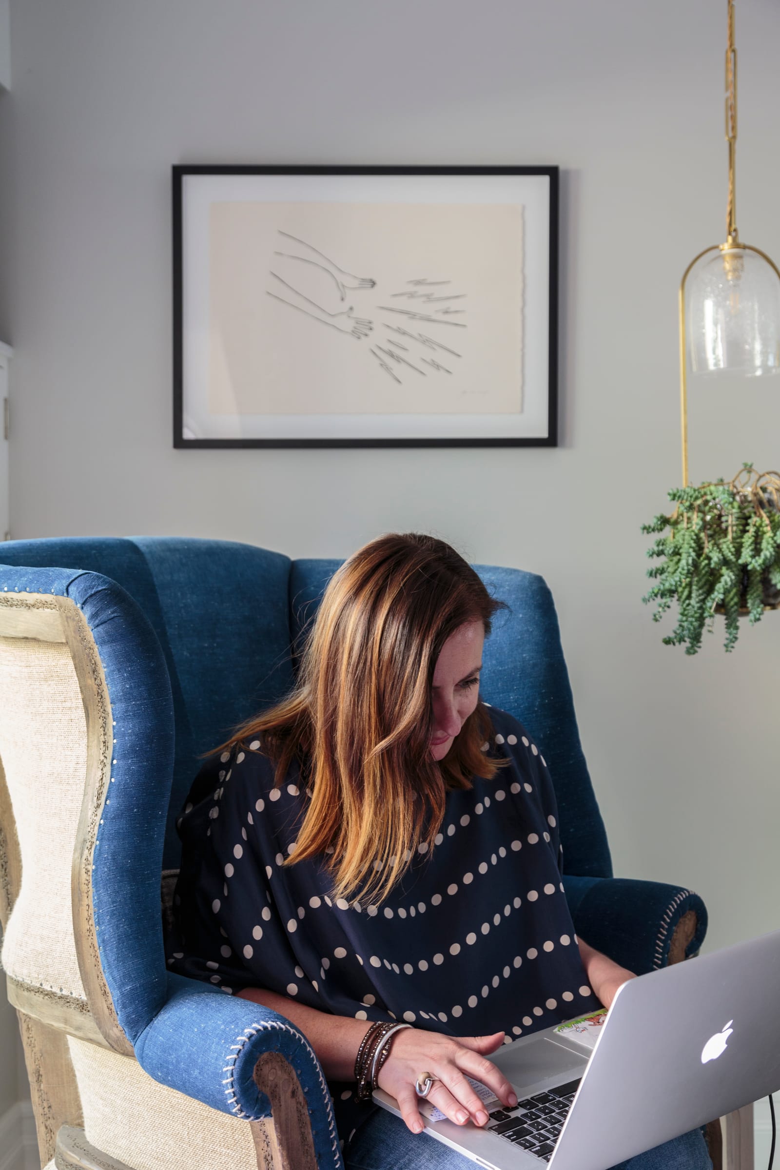 Bronwyn Poole working on laptop in blue armchair