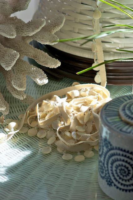 Coastal vignette with coral, shell garland, and blue ceramic jar