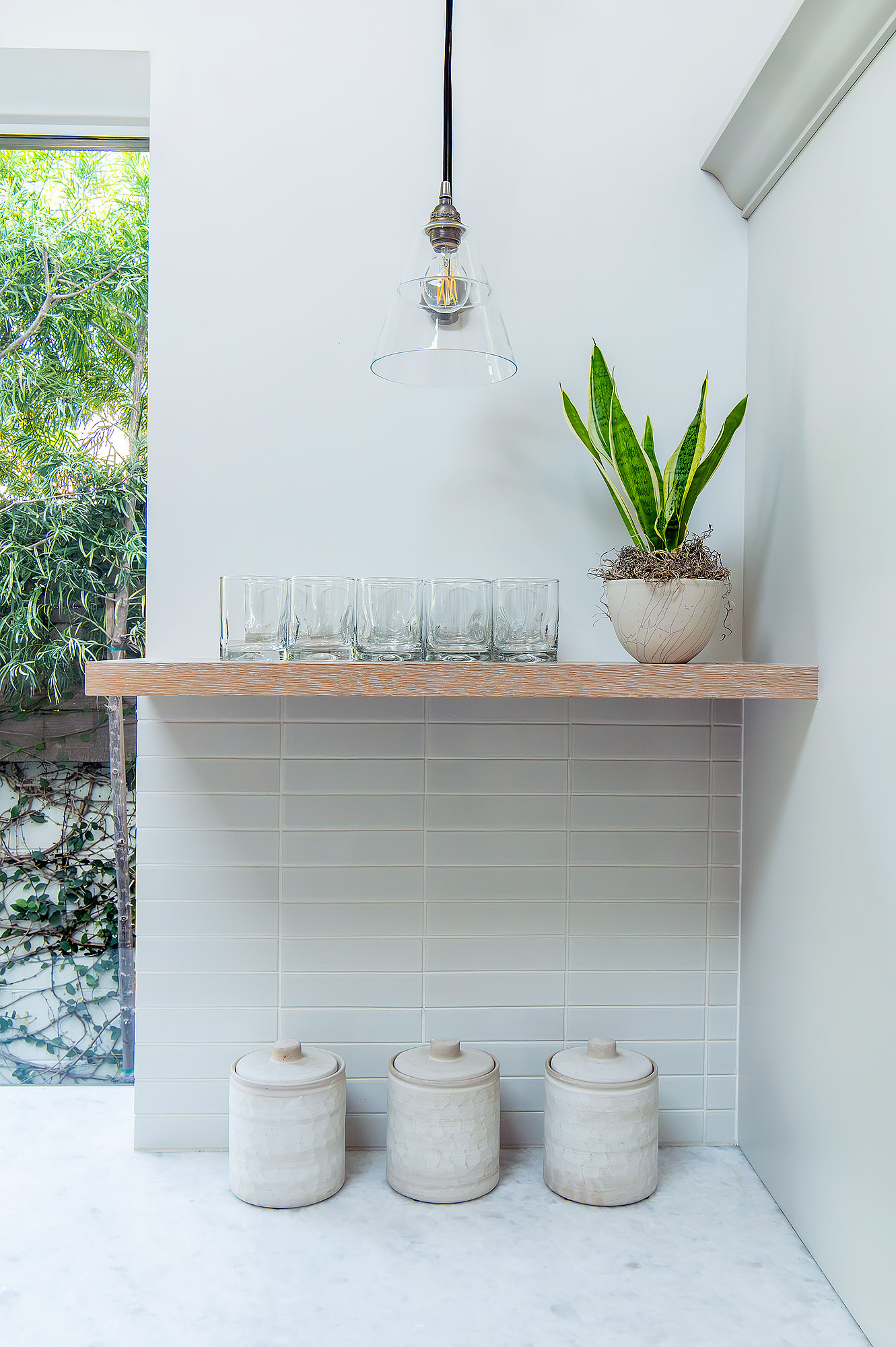 Kitchen glass pendant floating shelf water glasses snake plant stoneware canisters stacked tile — Bronwyn Poole Interiors Kitchen glass pendant floating shelf water glasses snake plant stoneware canisters stacked tile — Bronwyn Poole Interiors