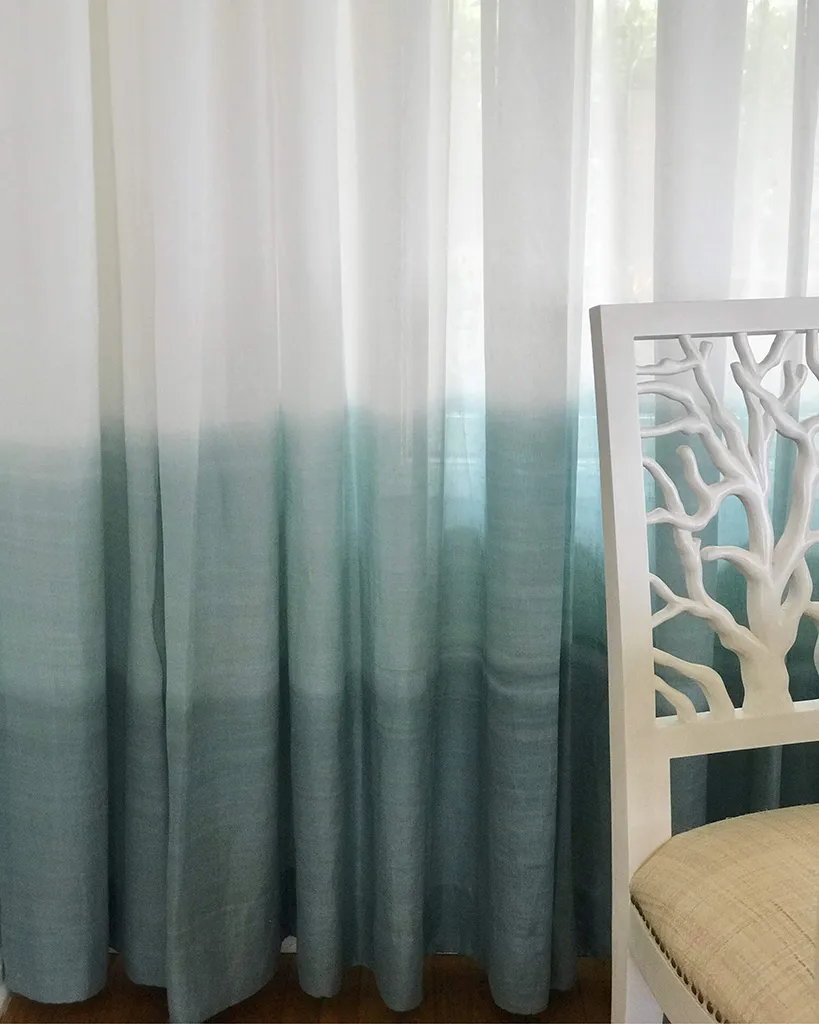 Ombré sheer curtains in teal gradient with white coral-motif chair — bespoke window textile design by Bronwyn Poole
