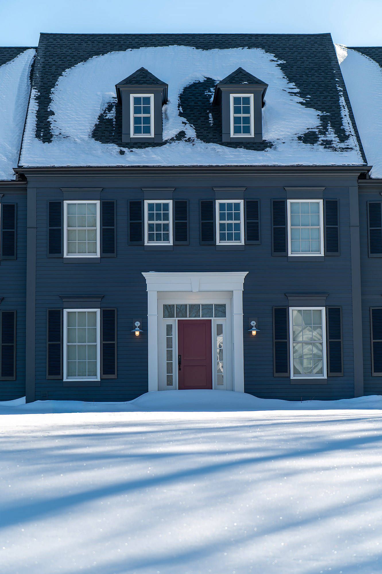 Colonial facade front elevation charcoal siding mansard roof dormer windows burgundy front door snow — Bronwyn Poole Interiors Colonial facade front elevation charcoal siding mansard roof dormer windows burgundy front door snow — Bronwyn Poole Interiors
