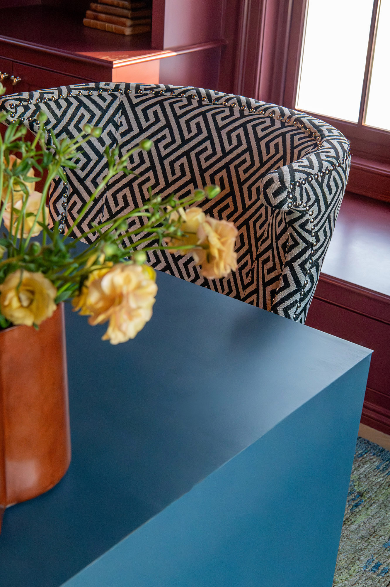 Den crimson greek key armchair detail nailhead trim blue lacquered desk edge leather pitcher yellow ranunculus — Bronwyn Poole Interiors