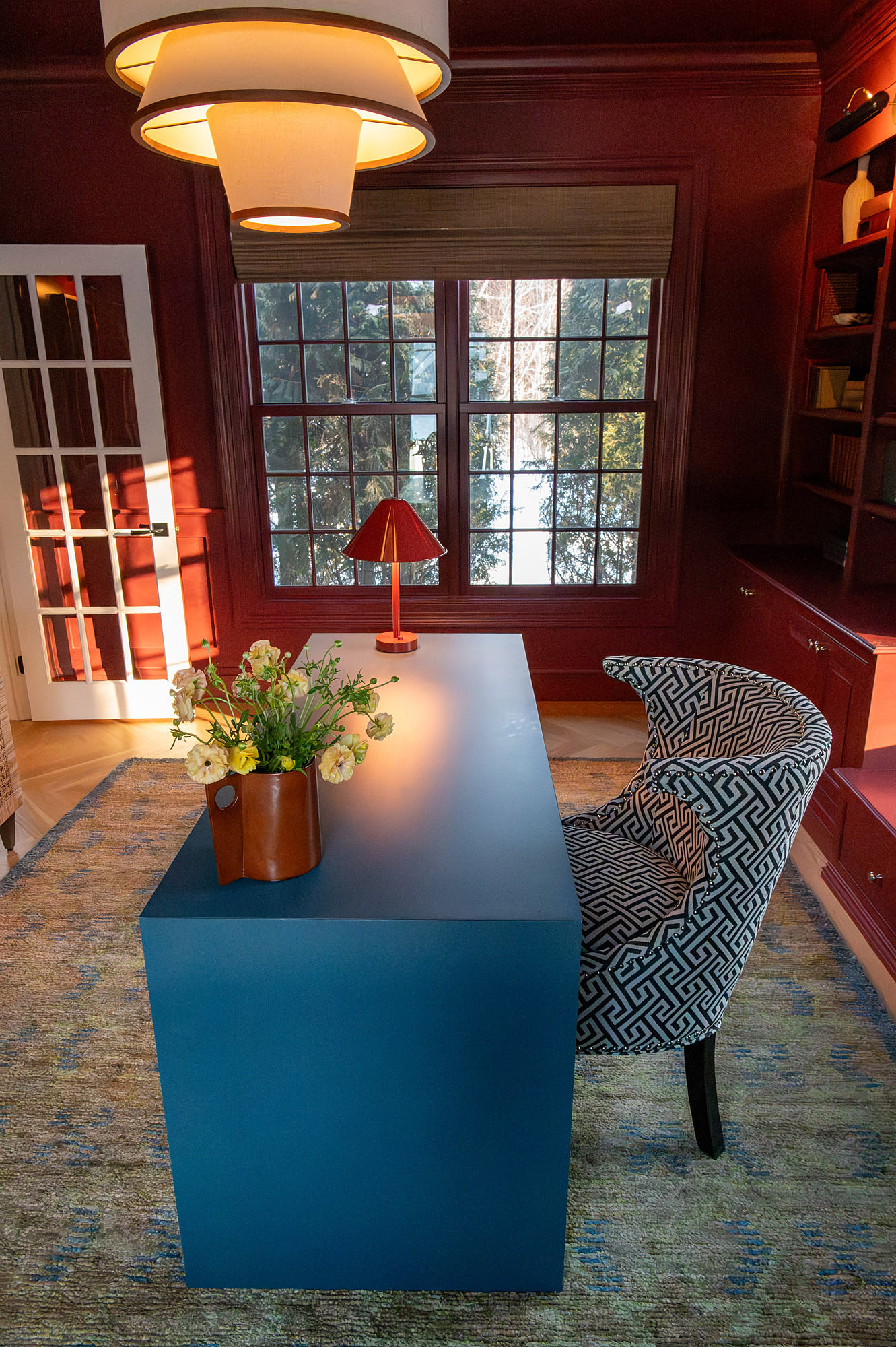Den crimson walls overhead view blue lacquered desk greek key armchair red task lamp leather pitcher ranunculus tiered pendants — Bronwyn Poole Interiors