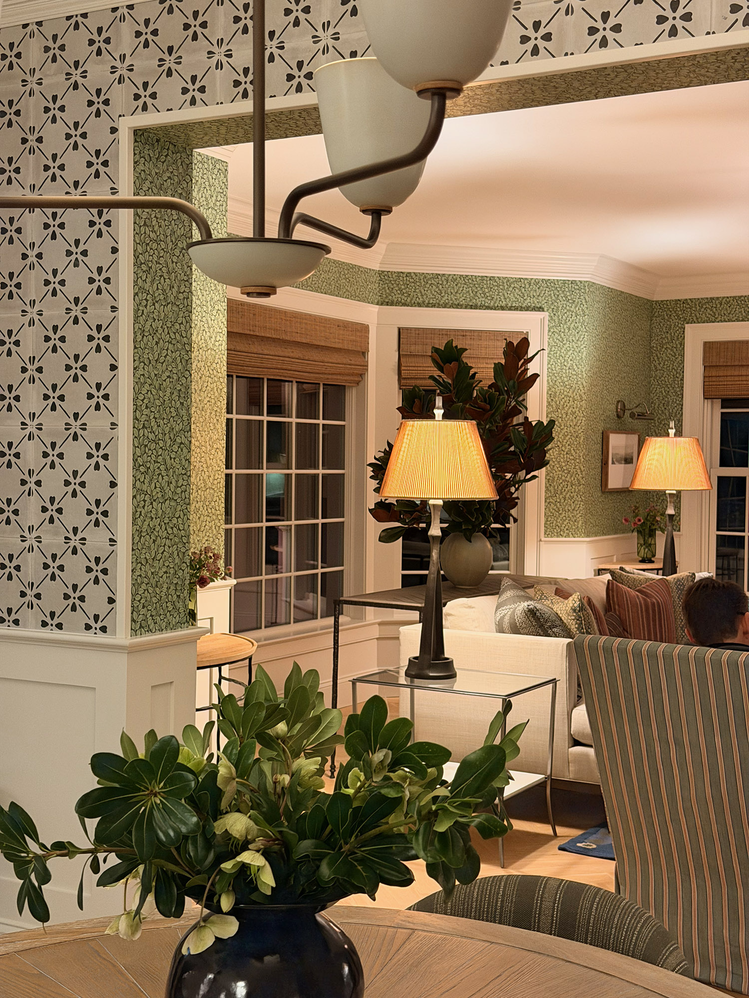 Dining area vista floral cement tile frieze green leaf wallpaper bronze chandelier magnolia vase pleated shade lamps living room view — Bronwyn Poole Interiors