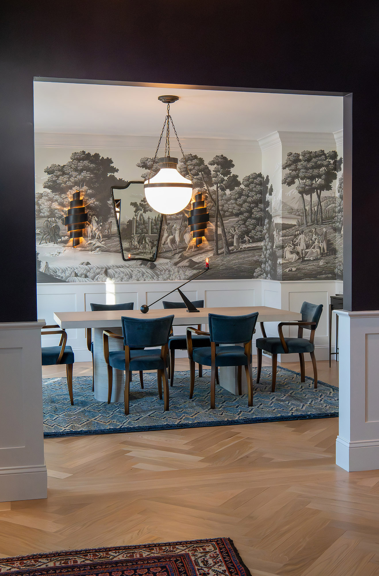 Formal dining vista through archway from dark hall globe pendant blue velvet chairs pedestal amaranth rug herringbone floor — Bronwyn Poole Interiors Formal dining vista through archway from dark hall globe pendant blue velvet chairs pedestal amaranth rug herringbone floor — Bronwyn Poole Interiors