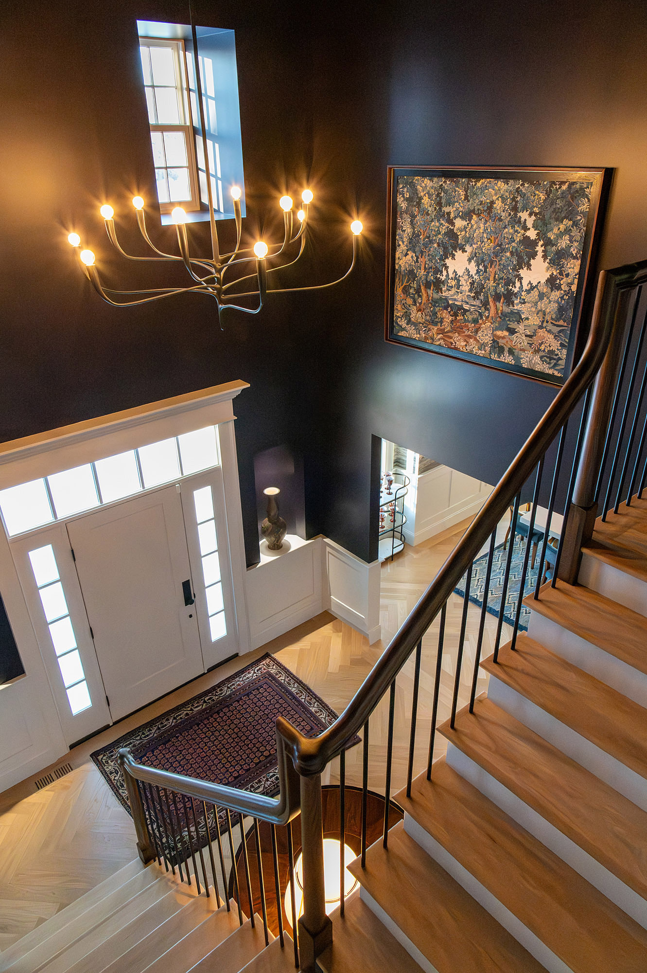 Foyer overhead view aubergine walls brass chandelier tapestry art oak staircase front door — Bronwyn Poole Interiors