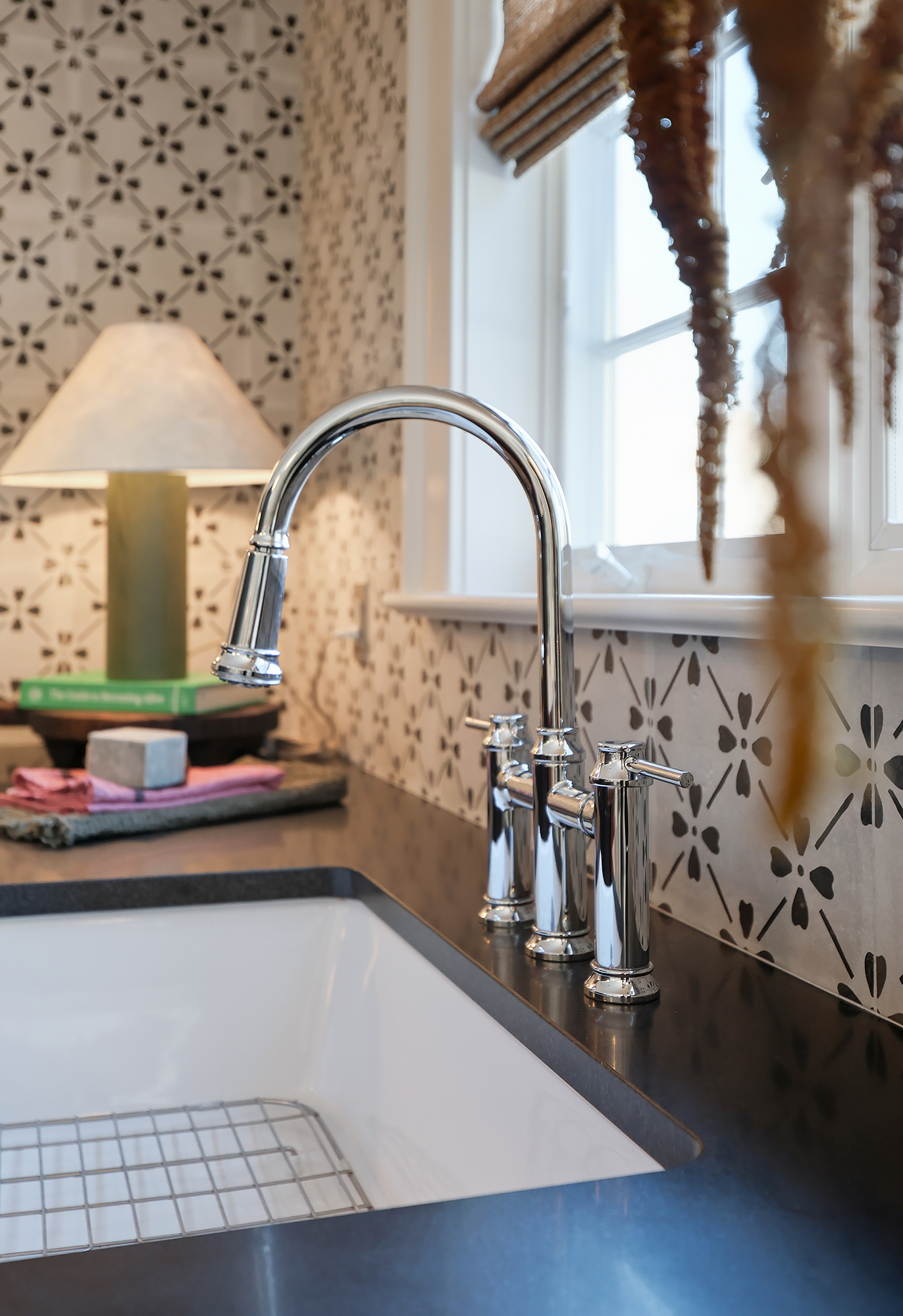 Kitchen sink detail chrome bridge faucet window amaranth tassels bamboo shade floral tile — Bronwyn Poole Interiors Kitchen sink detail chrome bridge faucet window amaranth tassels bamboo shade floral tile — Bronwyn Poole Interiors