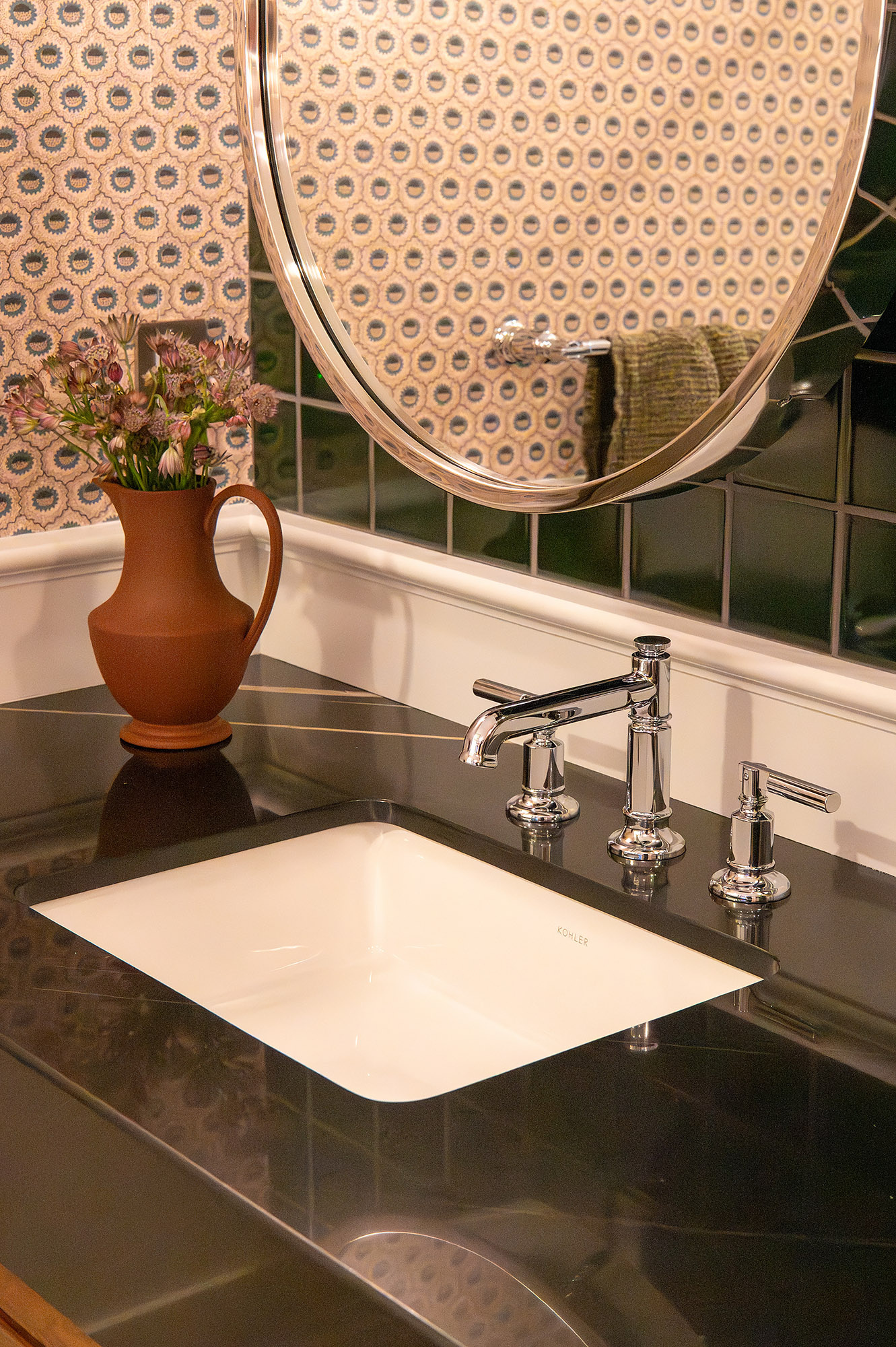 Primary bathroom vanity detail black marble counter kohler undermount sink terracotta pitcher pink flowers green tile — Bronwyn Poole Interiors