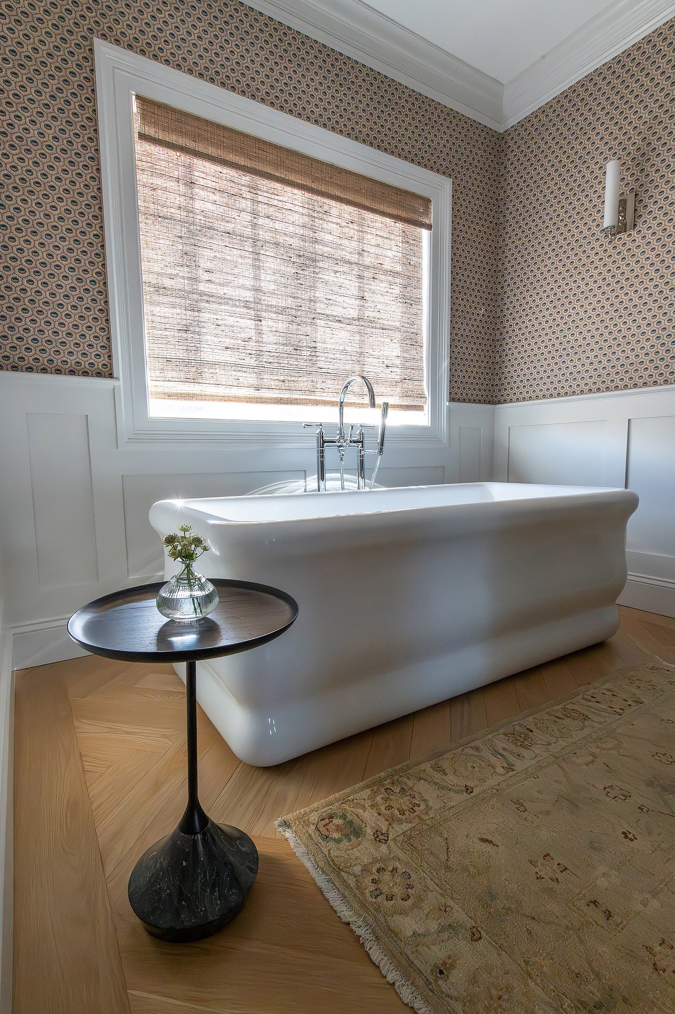 Primary bathroom wide view terracotta geometric wallpaper freestanding tub woven shade black spool side table floral rug — Bronwyn Poole Interiors Primary bathroom wide view terracotta geometric wallpaper freestanding tub woven shade black spool side table floral rug — Bronwyn Poole Interiors