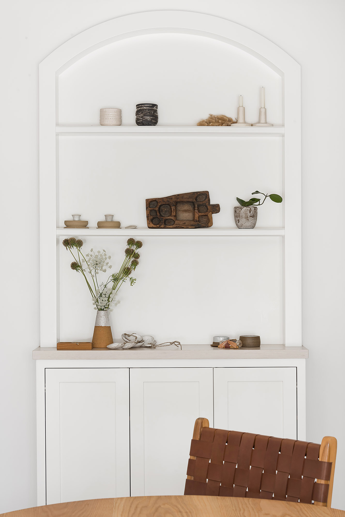 Arched built in shelving artisan ceramics wooden board dried flowers woven chair — Bronwyn Poole Interiors Arched built in shelving artisan ceramics wooden board dried flowers woven chair — Bronwyn Poole Interiors