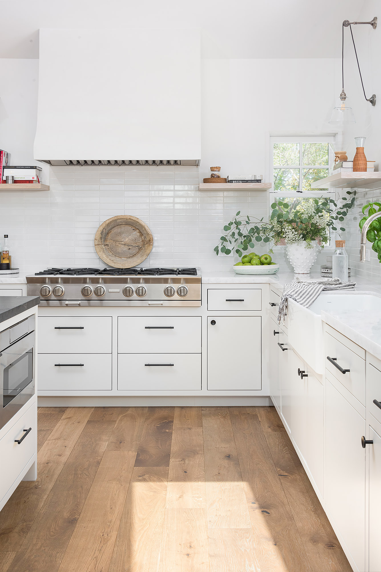 Kitchen detail white range hood subway tile floating shelves farmhouse sink brass sconce — Bronwyn Poole Interiors Kitchen detail white range hood subway tile floating shelves farmhouse sink brass sconce — Bronwyn Poole Interiors