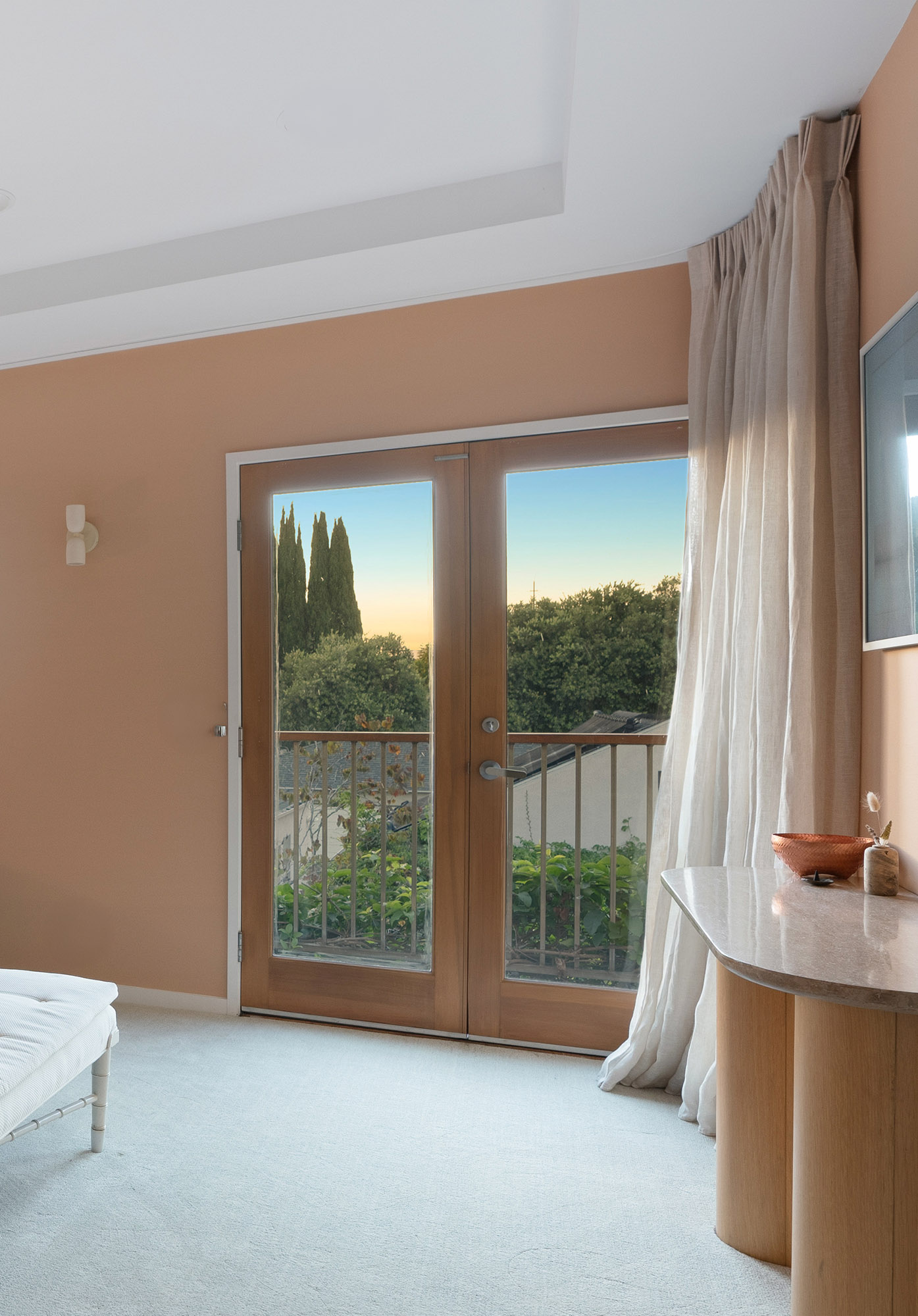 Santa monica primary bedroom peach walls french doors linen curtains sunset view detail — Bronwyn Poole Interiors Santa monica primary bedroom peach walls french doors linen curtains sunset view detail — Bronwyn Poole Interiors