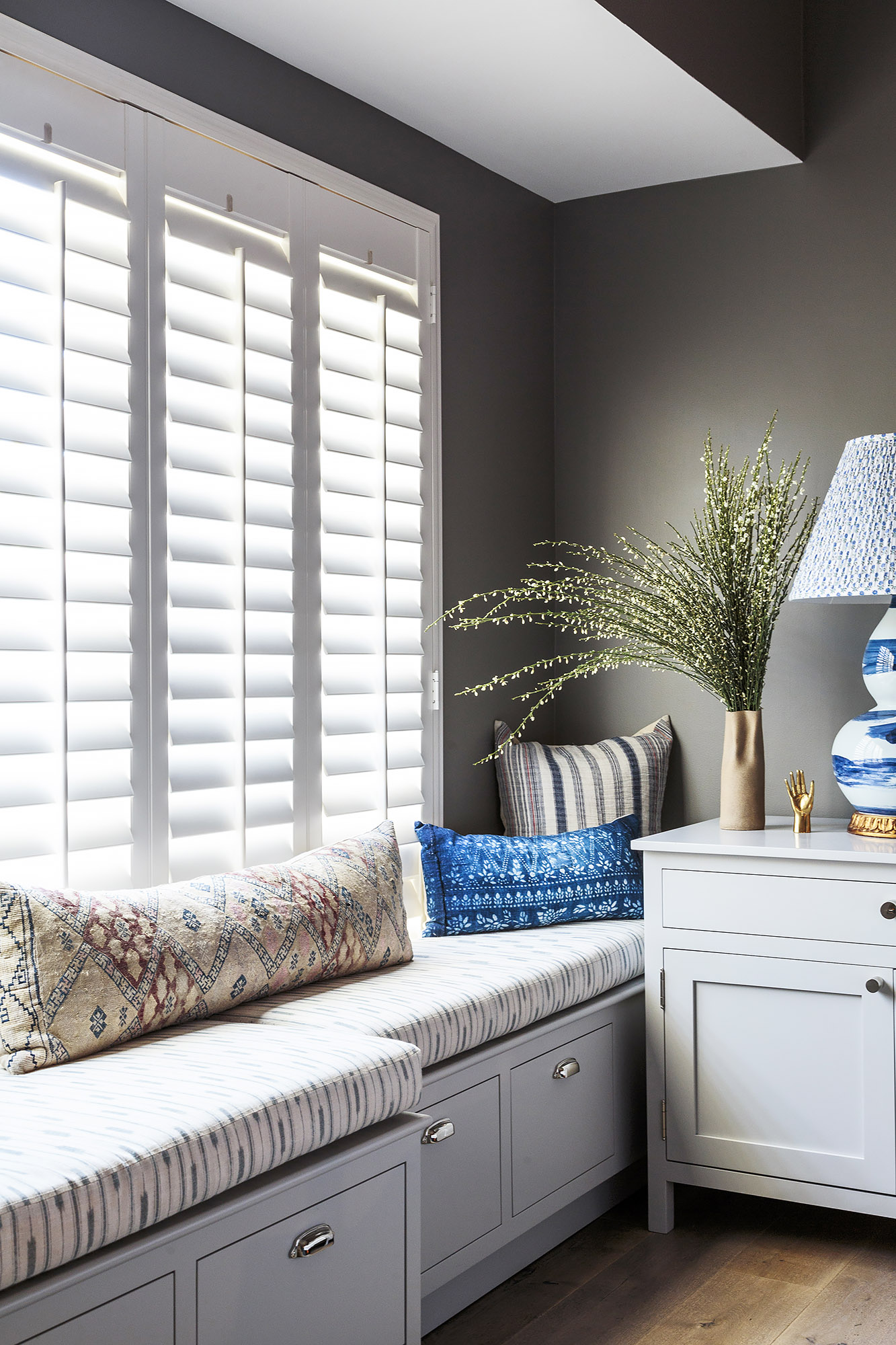 Primary bedroom window seat plantation shutters kilim pillow blue lamp — Bronwyn Poole Interiors Primary bedroom window seat plantation shutters kilim pillow blue lamp — Bronwyn Poole Interiors