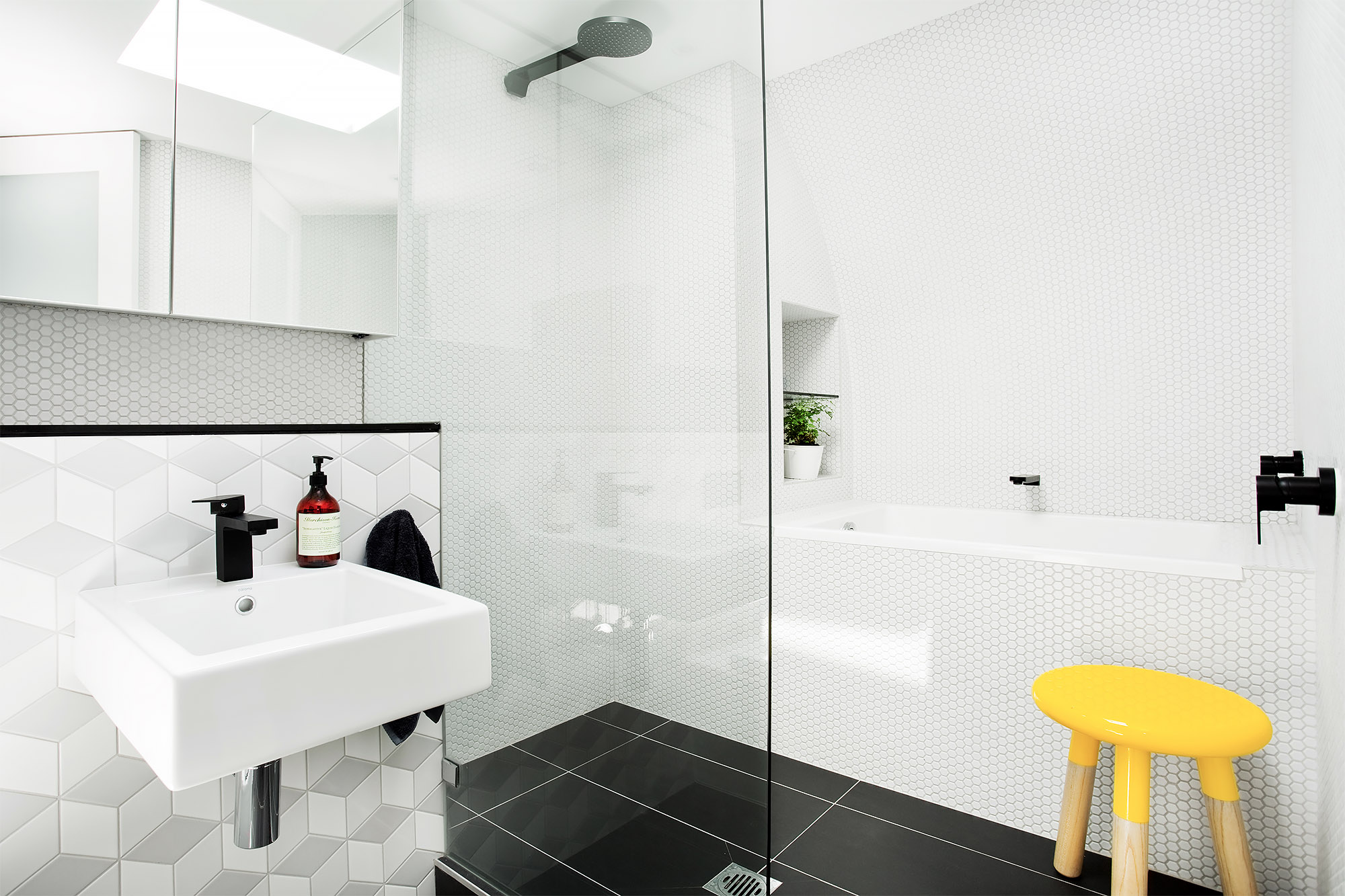 Bronwyn Poole Interiors Modern Bathroom White Hex Tile Geometric Tile Black Fixtures Glass Shower Skylight Yellow Stool — Interior Design by Bronwyn Poole